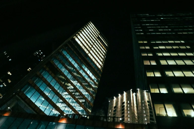 a couple of tall buildings next to each other, a screenshot, pexels contest winner, modernism, night time footage, glass and steel, low angle photo, cinematic view!!!