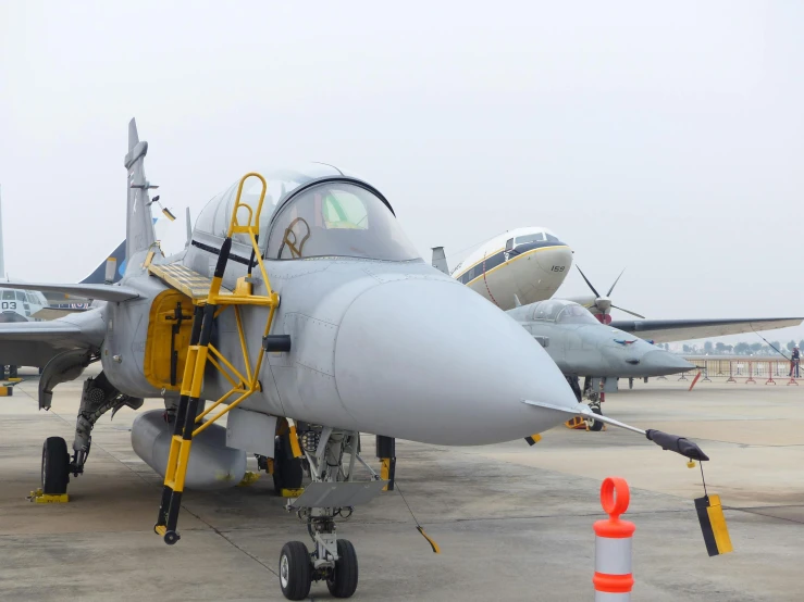 a fighter jet sitting on top of an airport tarmac, a portrait, by Daniel Lieske, shutterstock, nepal, slight overcast weather, avatar image, festivals