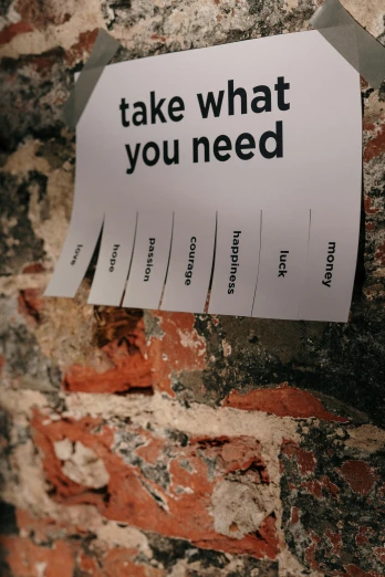 a sign on a brick wall that says take what you need, a poster, by Niko Henrichon, labels, diverse, tearing, help me