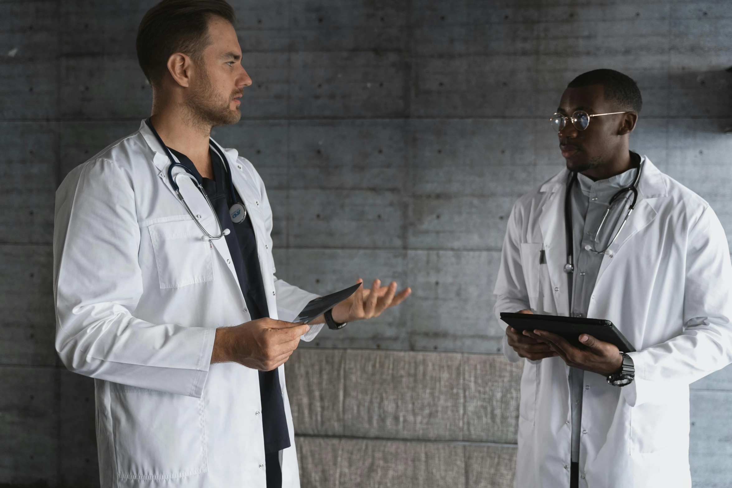 a couple of men standing next to each other, pexels, male physician, calmly conversing 8k, realistic », tech robes