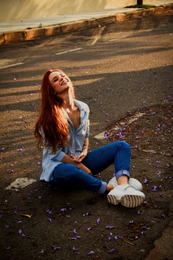 a woman sitting on the ground with her eyes closed, pexels contest winner, redhead girl, smiling :: attractive, 15081959 21121991 01012000 4k, tight blue jeans and cool shoes