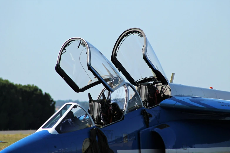 a blue fighter jet sitting on top of an airport tarmac, by Bernie D’Andrea, pexels contest winner, adult pair of twins, upper body close - up, sleek blue visor for eyes, welder wings