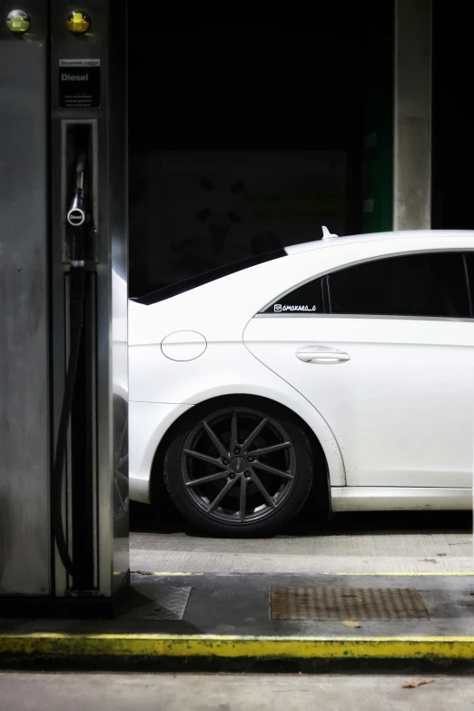 a white car parked in front of a gas station, profile image, white wheel rims, stealthy, ((sharp focus))