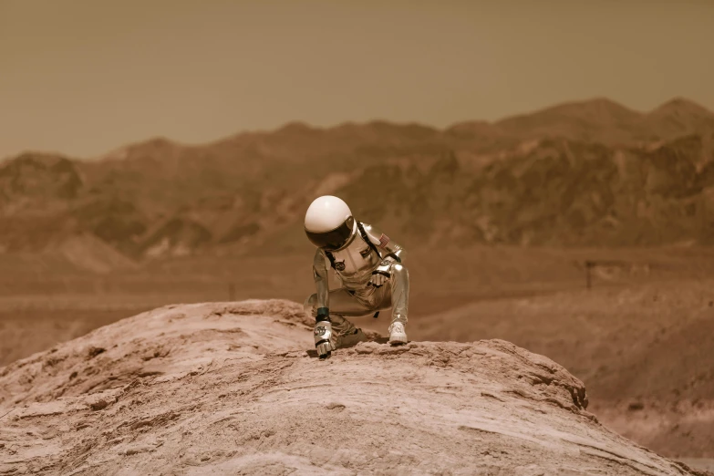 an astronaut sitting on a rock in the desert, pexels contest winner, helmet off, slightly pixelated, brown, 2022 photograph