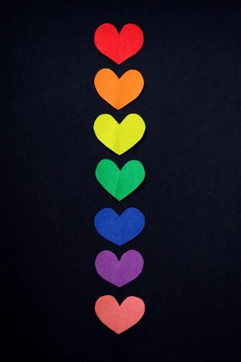 a rainbow of hearts on a black background, trending on pexels, colorful clothing, on dark paper, ilustration, dark. no text