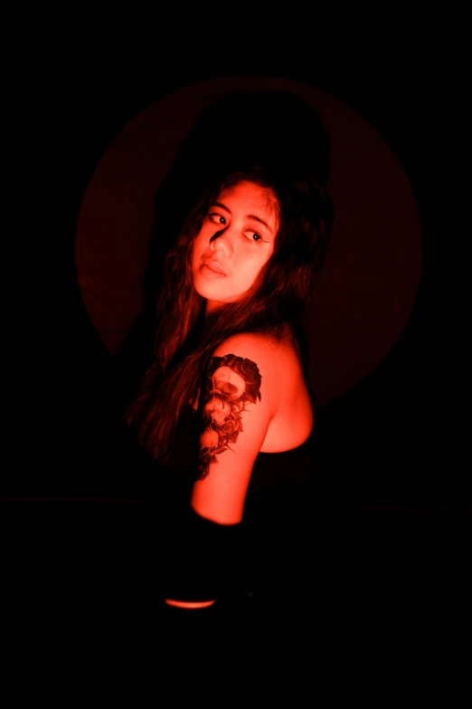 a woman with a tattoo on her arm in the dark, an album cover, by Max Dauthendey, unsplash, transgressive art, provocative indian, red lighting on their faces, sarah andersen, young woman with long dark hair