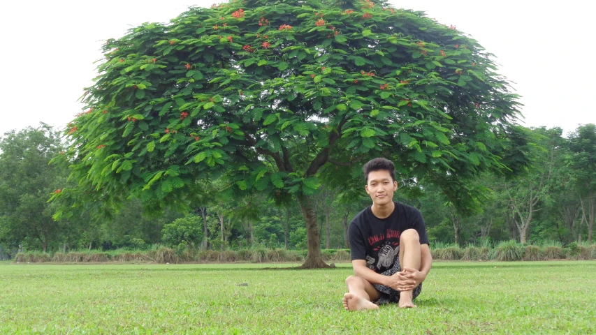 a man kneeling in the grass in front of a tree, a picture, inspired by Hong Ren, tumblr, sumatraism, avatar image, selfie photo, lush flora, college
