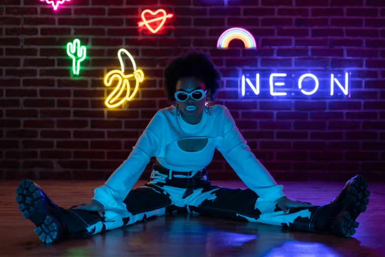 a woman sitting on the floor in front of neon signs, trending on pexels, neo-figurative, nerdy black girl super hero, neco arc, doja cat, neat