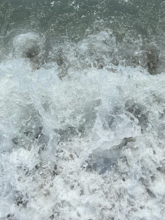 a man riding a wave on top of a surfboard, rushing water, extremely grainy, lots of bubbles, photo taken in 2018