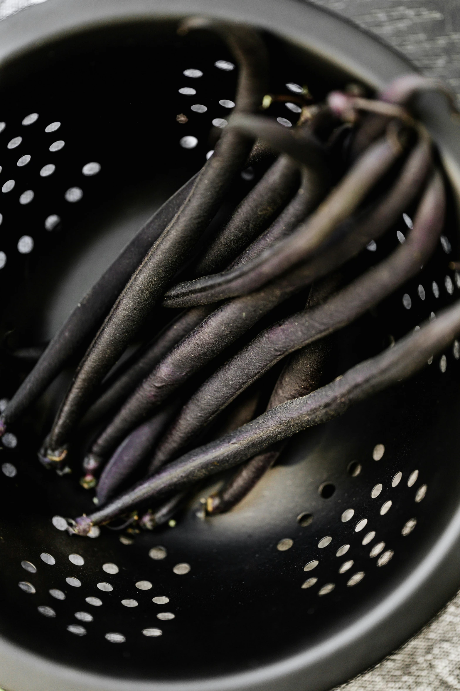 a colander with a bunch of beans in it, a digital rendering, unsplash, renaissance, dark purple, stems, black tendrils, high angle close up shot