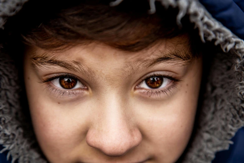 a close up of a person with a hood on, trending on pexels, hyperrealism, brown hair and large eyes, young boy, eye level shot, 50 mm lens photo portrait