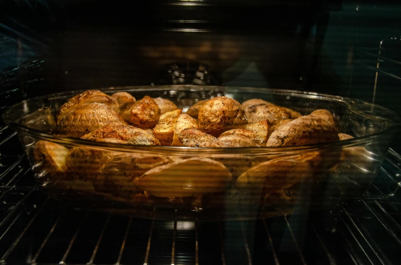 a bowl filled with chicken sitting inside of an oven, by Matt Cavotta, pexels contest winner, potatoes, clear focused details, kek, loaves