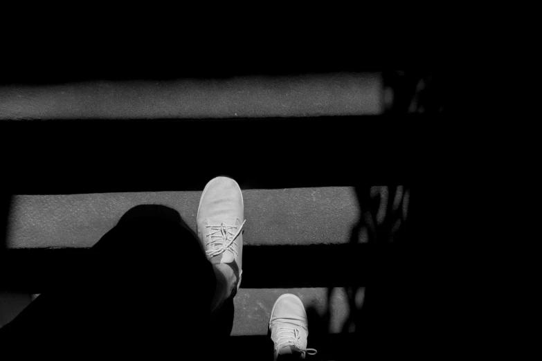 a person standing on a set of stairs, a black and white photo, by Jan Rustem, unsplash, white shoes, takato yomamoto. 4 k, high contrast!!, consist of shadow