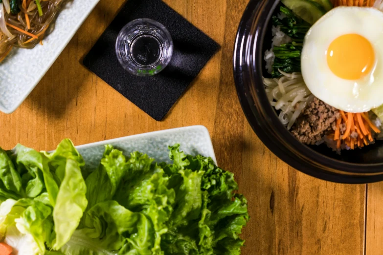 a wooden table topped with plates of food, a portrait, by Jason Felix, unsplash, lettuce, korean, background image, square