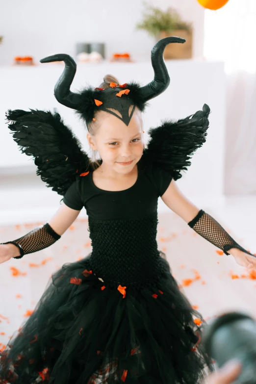 a little girl dressed up in a halloween costume, pexels contest winner, symbolism, black wings instead of arms, girl design lush horns, low quality photo, angeline jolie