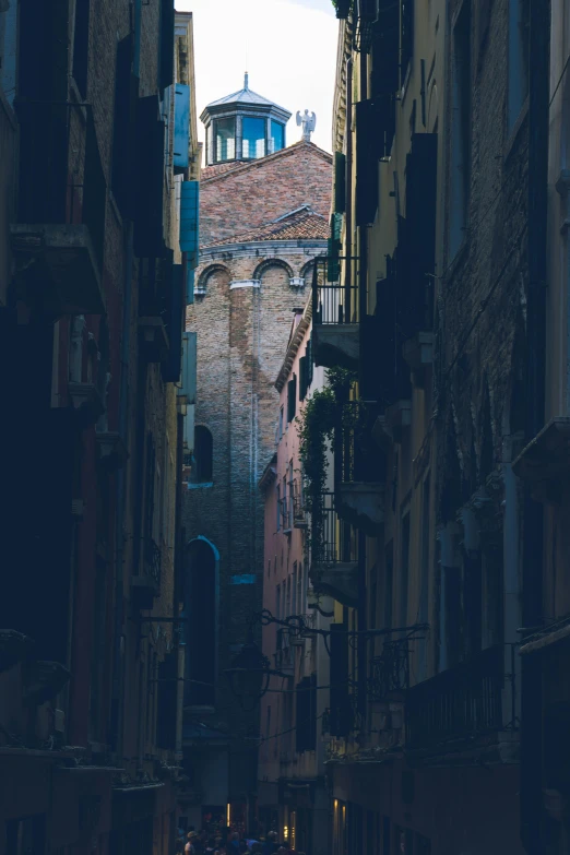 a narrow alley with a clock tower in the background, an album cover, unsplash contest winner, renaissance, venice, overview, contrasting light, stacked image