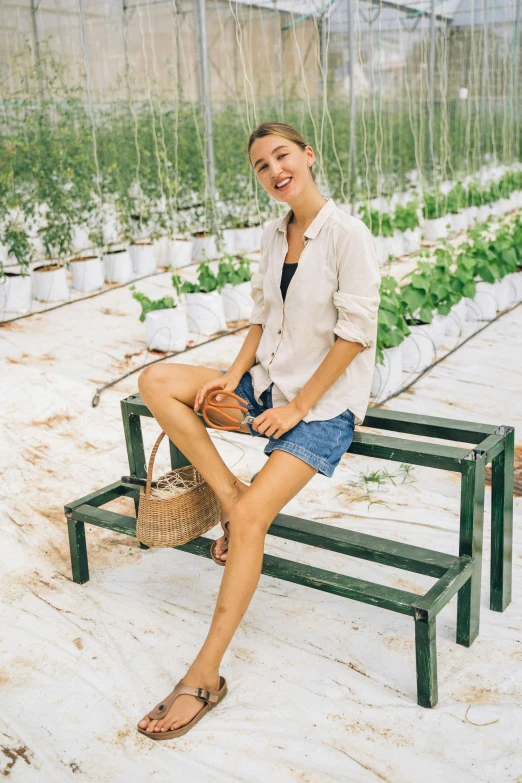 a woman sitting on a bench in a greenhouse, a picture, trending on unsplash, renaissance, wears shorts, smiling fashion model, straw, taiwan