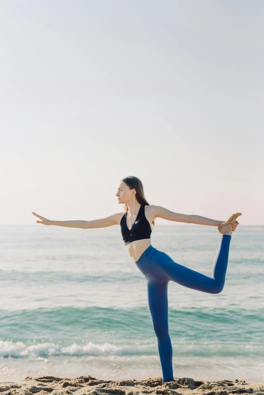 a woman doing a yoga pose on the beach, pexels contest winner, arabesque, full body with dynamic pose, avatar image, blue, hip-length