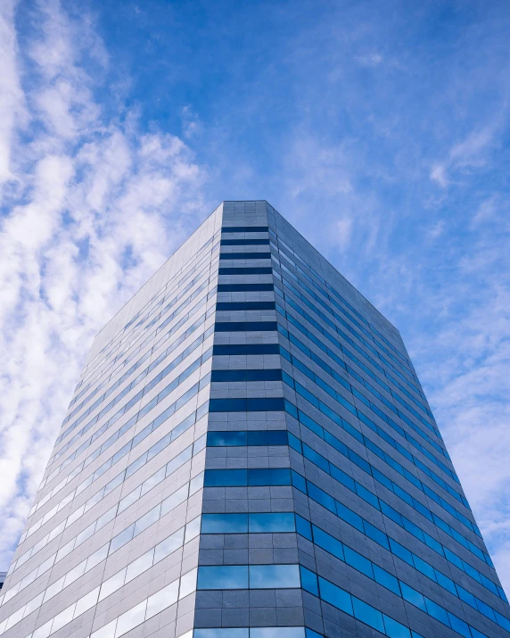 a very tall building with a lot of windows, unsplash, light blue sky with clouds, thumbnail, multiple stories, capital plaza
