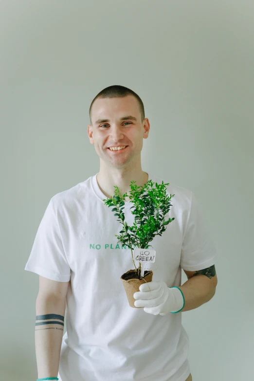 a man in a white shirt holding a potted plant, photo taken in 2 0 2 0, danila tkachenko, cleanest image, slightly smiling