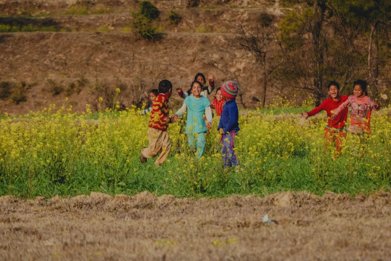 a group of children standing next to each other in a field, pexels contest winner, uttarakhand, local people chasing to attack, ecovillage, mustard