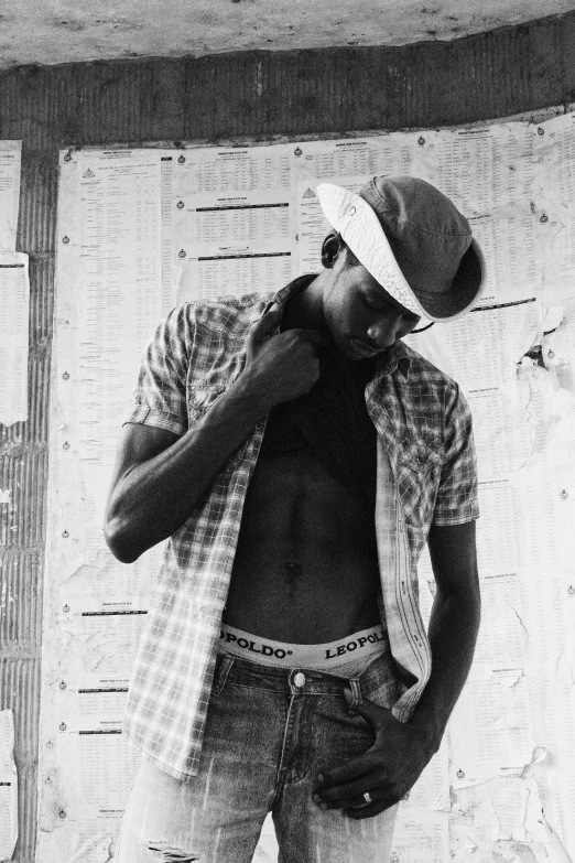 a black and white photo of a shirtless man, a black and white photo, by Clifford Ellis, wears a destroyed hat, young thug, wearing farm clothes, 2007