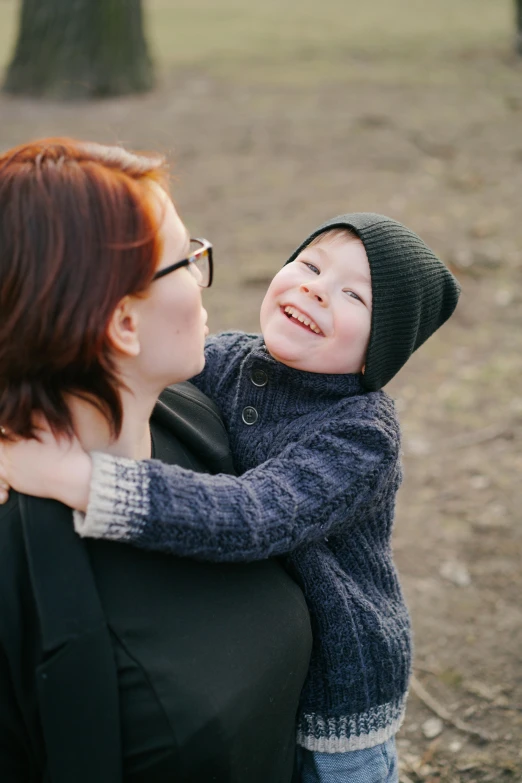 a woman holding a child in a park, pexels contest winner, brunette boy and redhead boy, orthodox, 15081959 21121991 01012000 4k, smooth texture