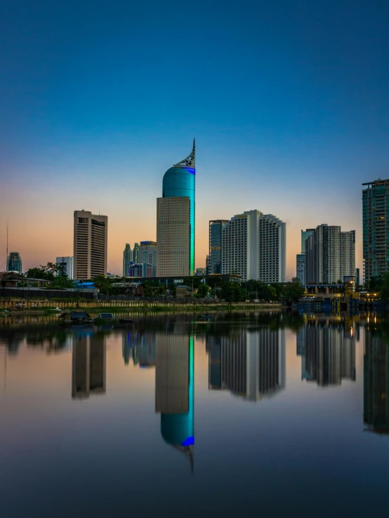 a large body of water surrounded by tall buildings, a picture, by Erik Pevernagie, pexels contest winner, hurufiyya, colored photo, square, calm evening, indonesia national geographic