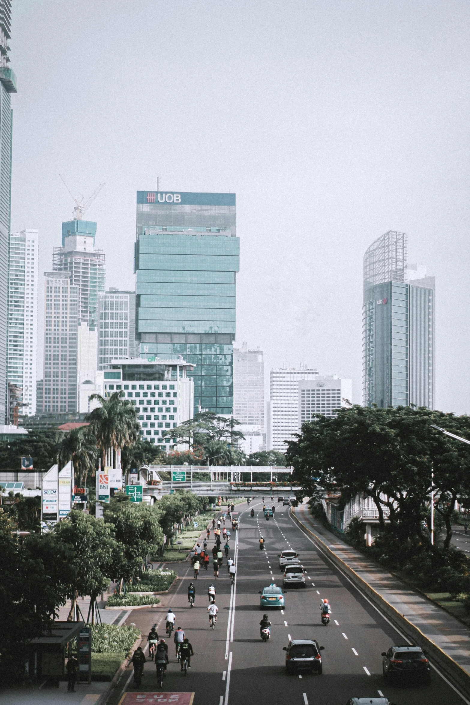 a street filled with lots of traffic next to tall buildings, unsplash contest winner, indonesia, commercial banner, square, low quality photo