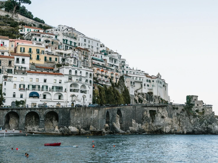 a group of boats floating on top of a body of water, a photo, by Anita Malfatti, pexels contest winner, renaissance, cliffside town, white sweeping arches, 2 5 6 x 2 5 6 pixels, white pale concrete city