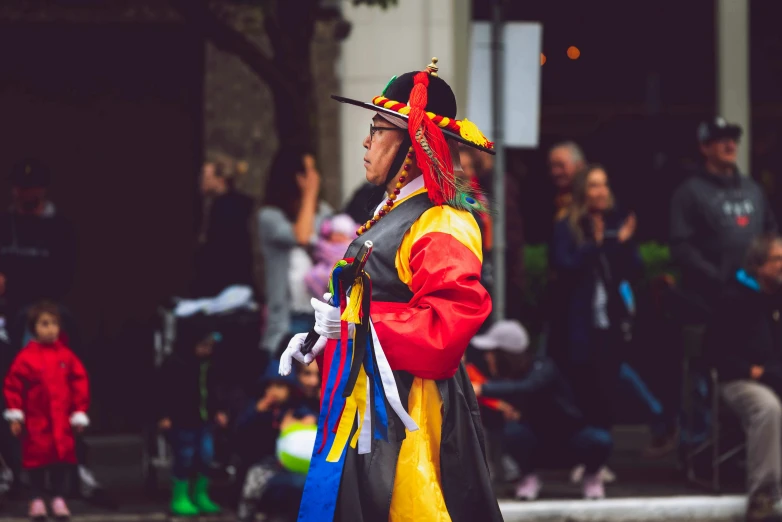 a man in a colorful costume walking down the street, pexels contest winner, korean woman, square, thumbnail, concert photo