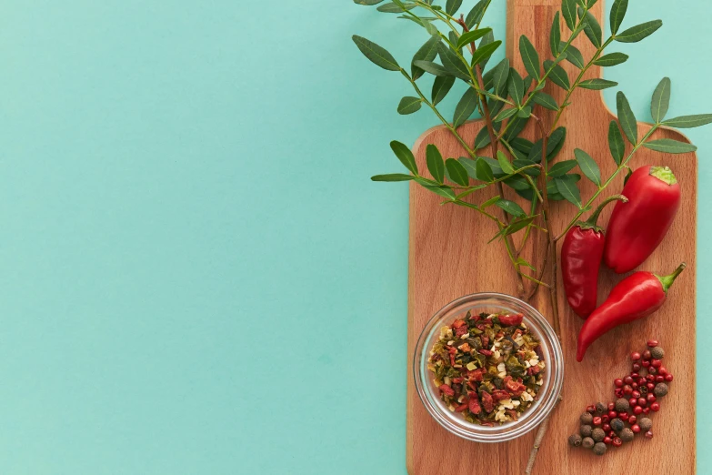 a wooden cutting board topped with red peppers, a still life, trending on pexels, teal studio backdrop, dried herbs, background image, 9 9 designs