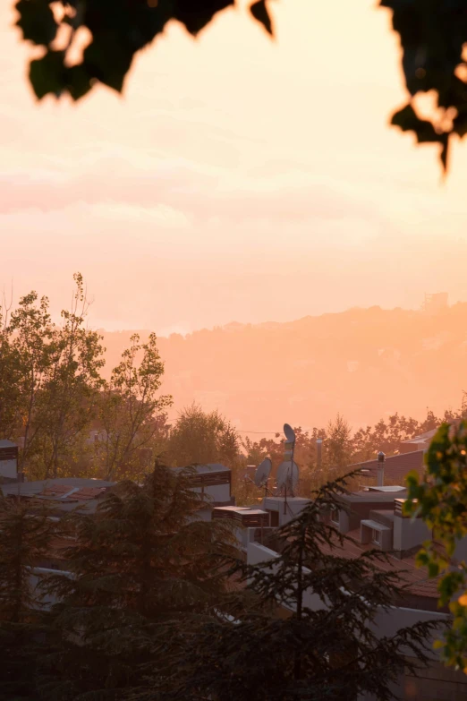 a large clock tower towering over a city, a matte painting, inspired by Evgeny Lushpin, unsplash, romanticism, sunset in a valley, mulholland drive, today\'s featured photograph 4k, trees in foreground