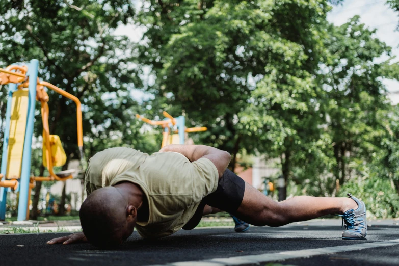 a man doing push ups on a playground, pexels contest winner, heroic shooting bow pose, nature outside, background image, thumbnail