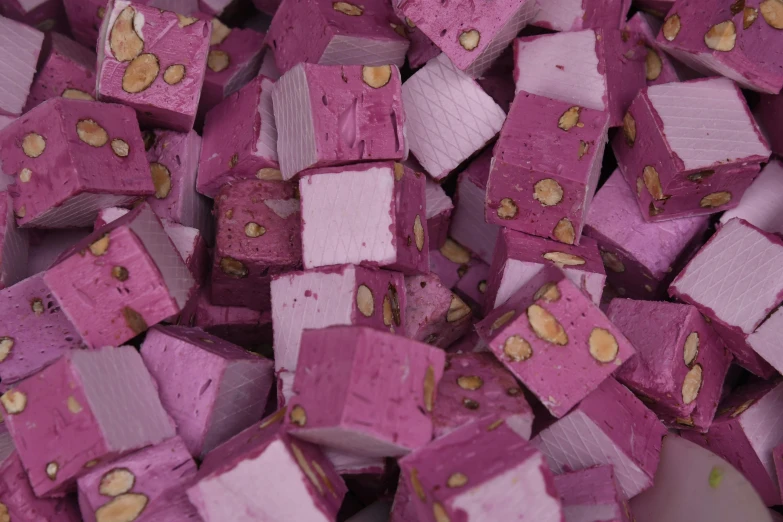 a pile of pink cubes sitting on top of a table, gold flakes, purple flesh, raspberry banana color, detailed product image