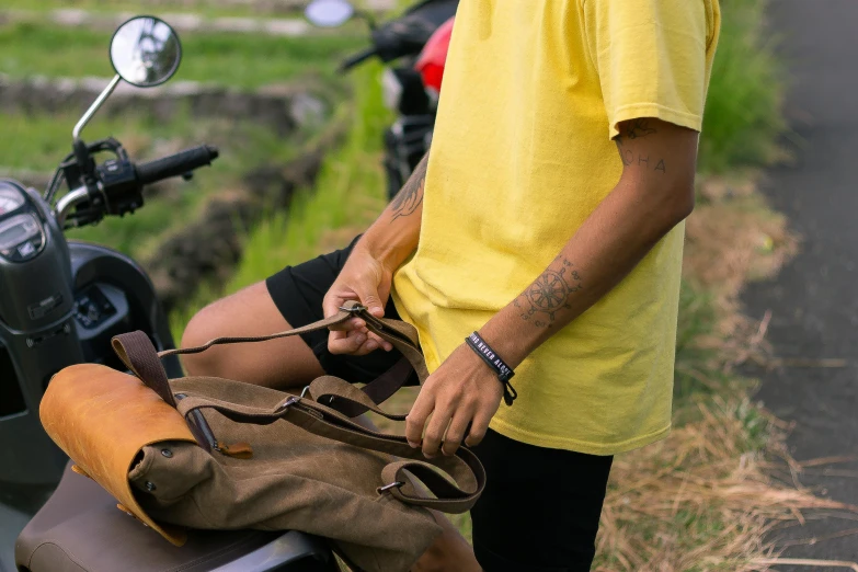 a man in a yellow shirt is sitting on a motorcycle, pexels contest winner, small vials and pouches on belt, bali, avatar image, wearing casual clothing