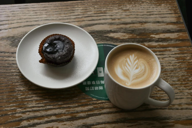 a cup of coffee and a muffin on a table, inspired by Richmond Barthé, hurufiyya, built on a small, an abandoned, round, take