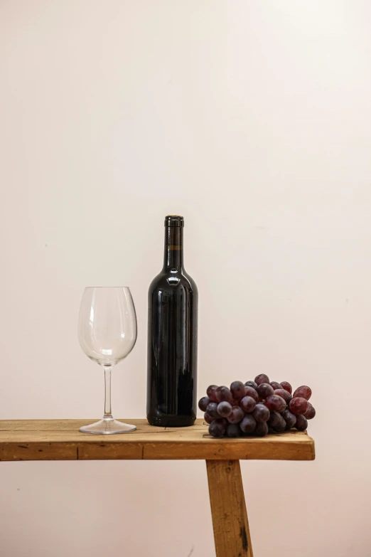 a bottle of wine sitting on top of a wooden table, a still life, pexels contest winner, realism, set against a white background, realistic », large vines, modern minimalist f 2 0