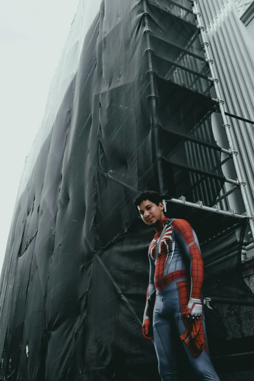 a man standing in front of a tall building, inspired by Adam Dario Keel, full samurai armor spiderman, cai xukun, low quality photo, hero