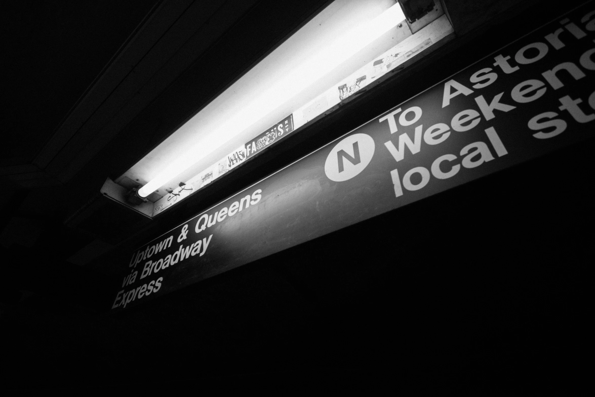 a black and white photo of a subway sign, a black and white photo, by Adam Rex, unsplash, the city that never sleeps, on the qt, on black paper, from east to west