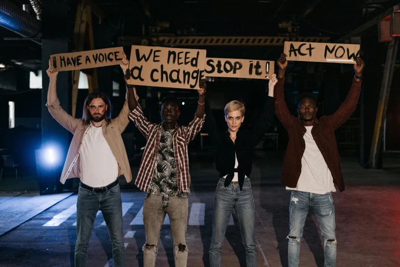 a group of people holding up a sign, pexels, antipodeans, bleached, actor, standing in a dark, asking for change