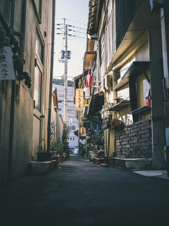 a narrow city street lined with tall buildings, a picture, unsplash contest winner, mingei, nagasaki, vintage vibe, shady alleys, a quaint