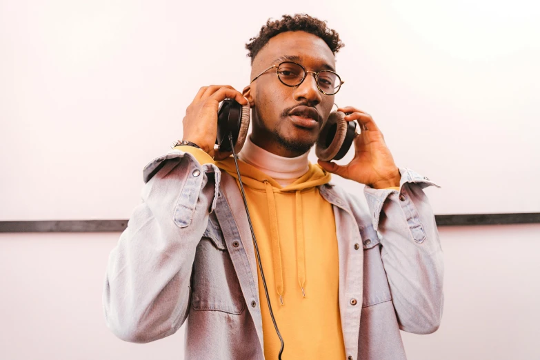 a man holding a pair of headphones to his ear, inspired by Theo Constanté, trending on pexels, ashteroth, portrait of tall, 15081959 21121991 01012000 4k, coloured