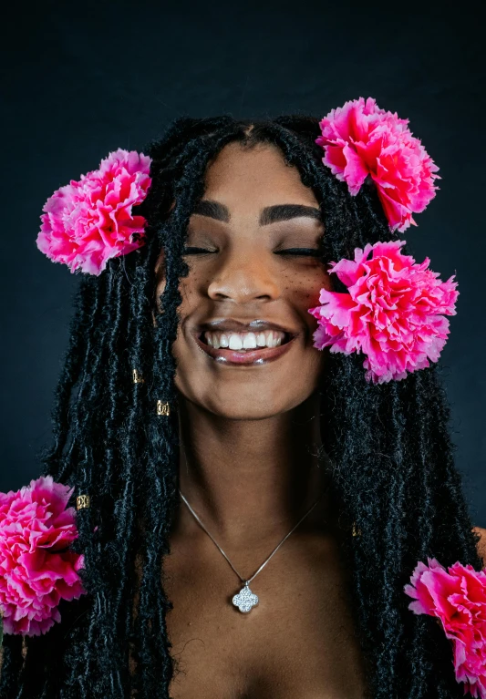 a woman with pink flowers in her hair, pexels contest winner, black arts movement, smiling young woman, dreadlock black hair, promo image, photo of a model