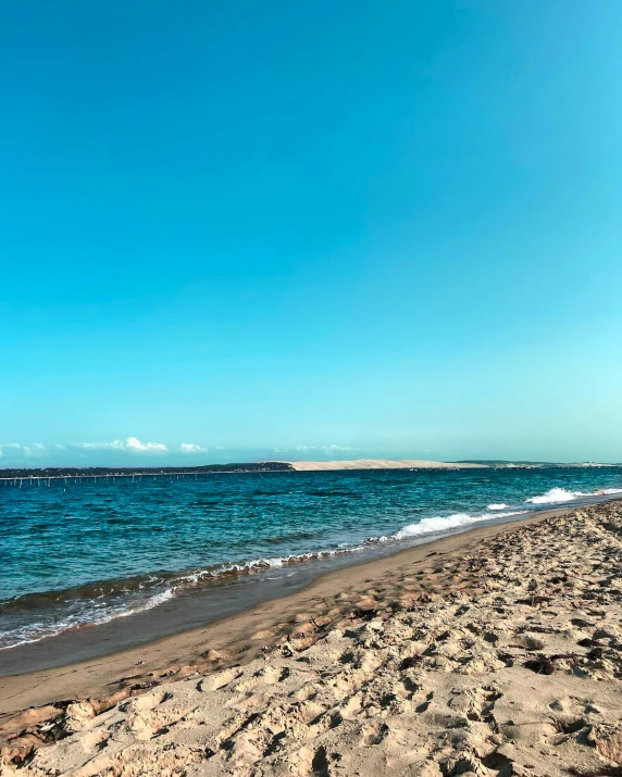 a man flying a kite on top of a sandy beach, photo of the middle of the ocean, clear blue skies, azores, instagram story