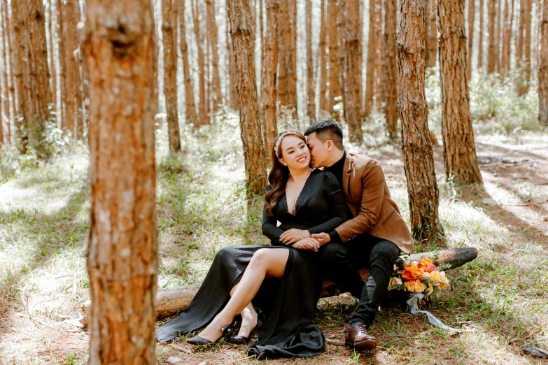 a man and woman sitting on a bench in the woods, a portrait, by Julia Pishtar, pexels contest winner, ao dai, pine forest, youtube thumbnail, black