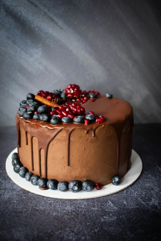 a chocolate cake sitting on top of a white plate, berries dripping, handcrafted, best selling, thumbnail