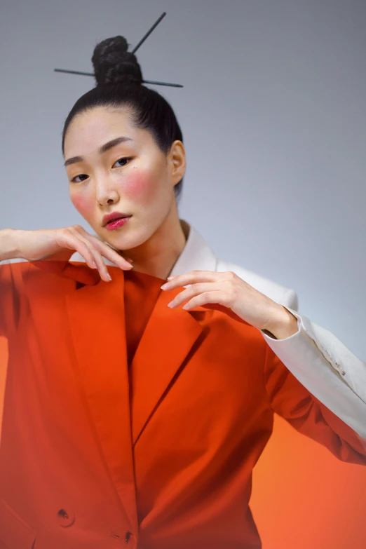 a woman in an orange suit posing for a picture, inspired by Gao Xiang, trending on pexels, hyperrealism, soft grey and red natural light, ethnicity : japanese, high fashion superpowers, hong june hyung