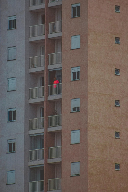 a couple of tall buildings sitting next to each other, an album cover, inspired by Elsa Bleda, pexels contest winner, fantastic realism, colors red, tiny person watching, nazare (portugal), surveillance