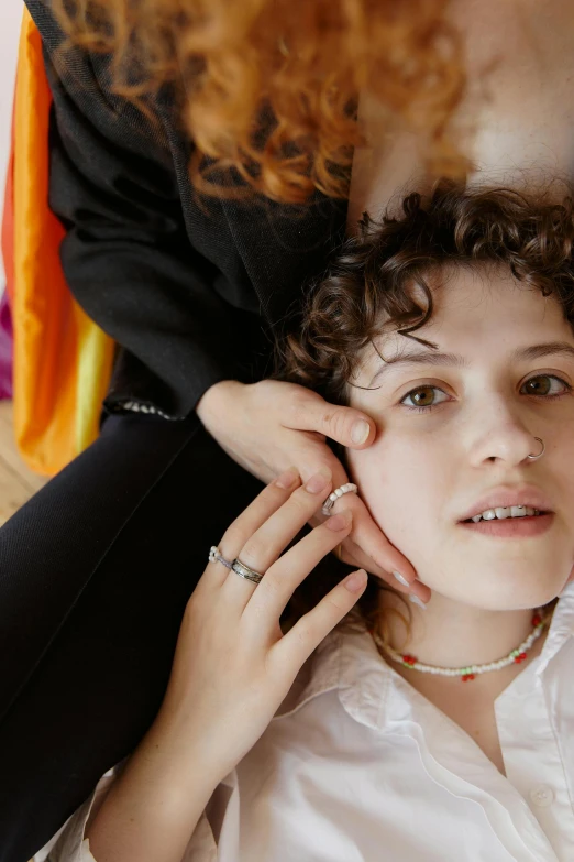 a woman getting her hair done by a hair stylist, an album cover, by Nathalie Rattner, yung lean, close-up portrait film still, hand on cheek, rainbow accents